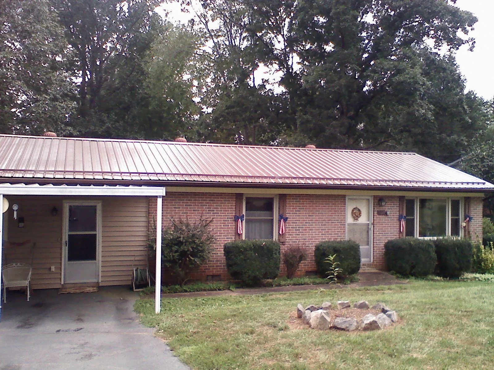 Bronze metal roof and carport on a brick ranch home — Roof Repair work by our crew in Millington